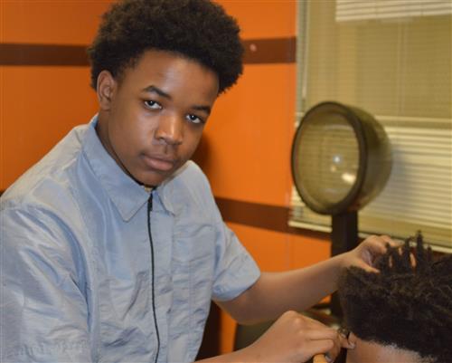 Barbering student cutting hair 